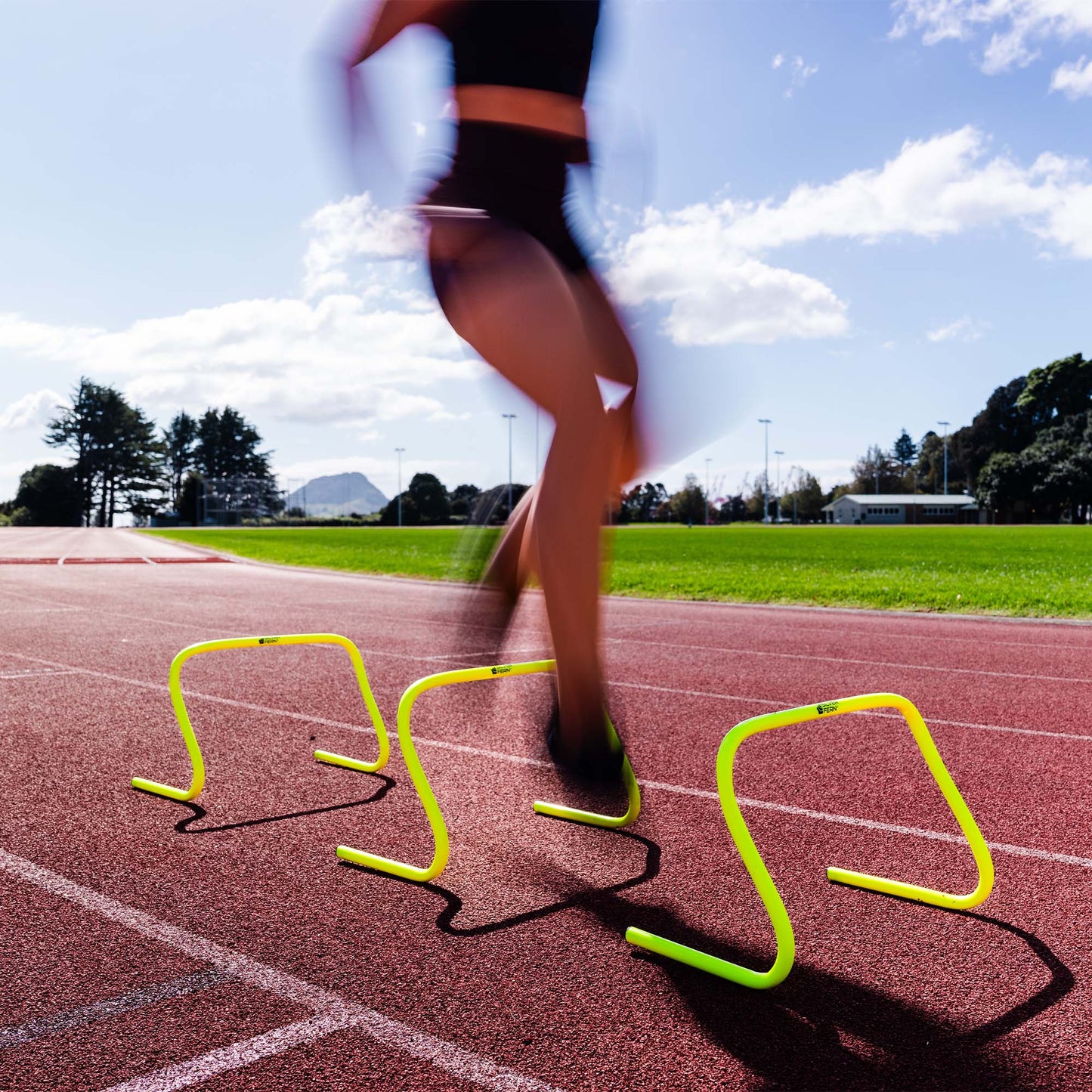 A lifestyle shot of a Set of 30 cm Agility Hurdles being used by an Athlete.