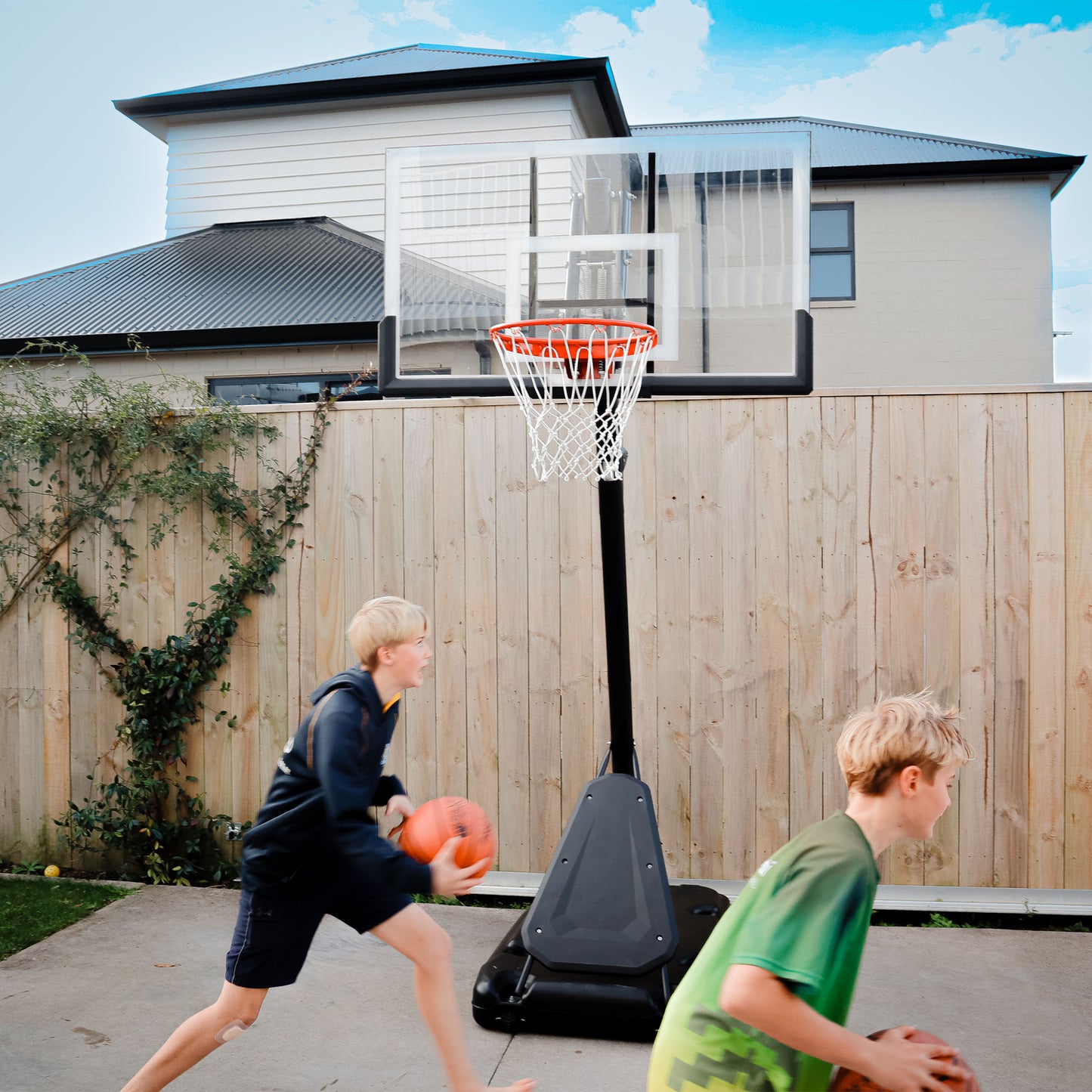 Boys using premier basketball system backyard