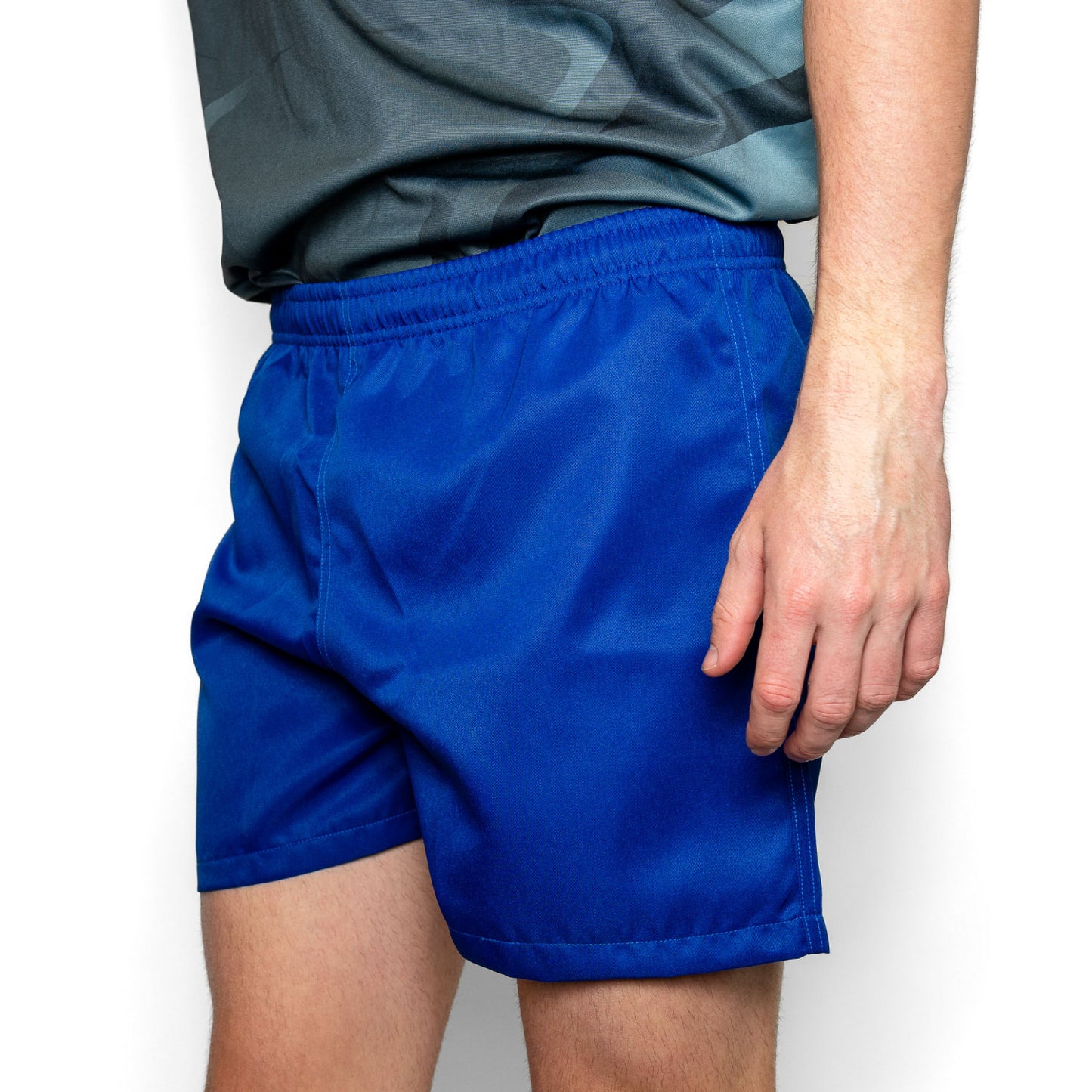 Silver Fern Royal Blue Rugby Shorts. Rugby Player Posing. White Background.