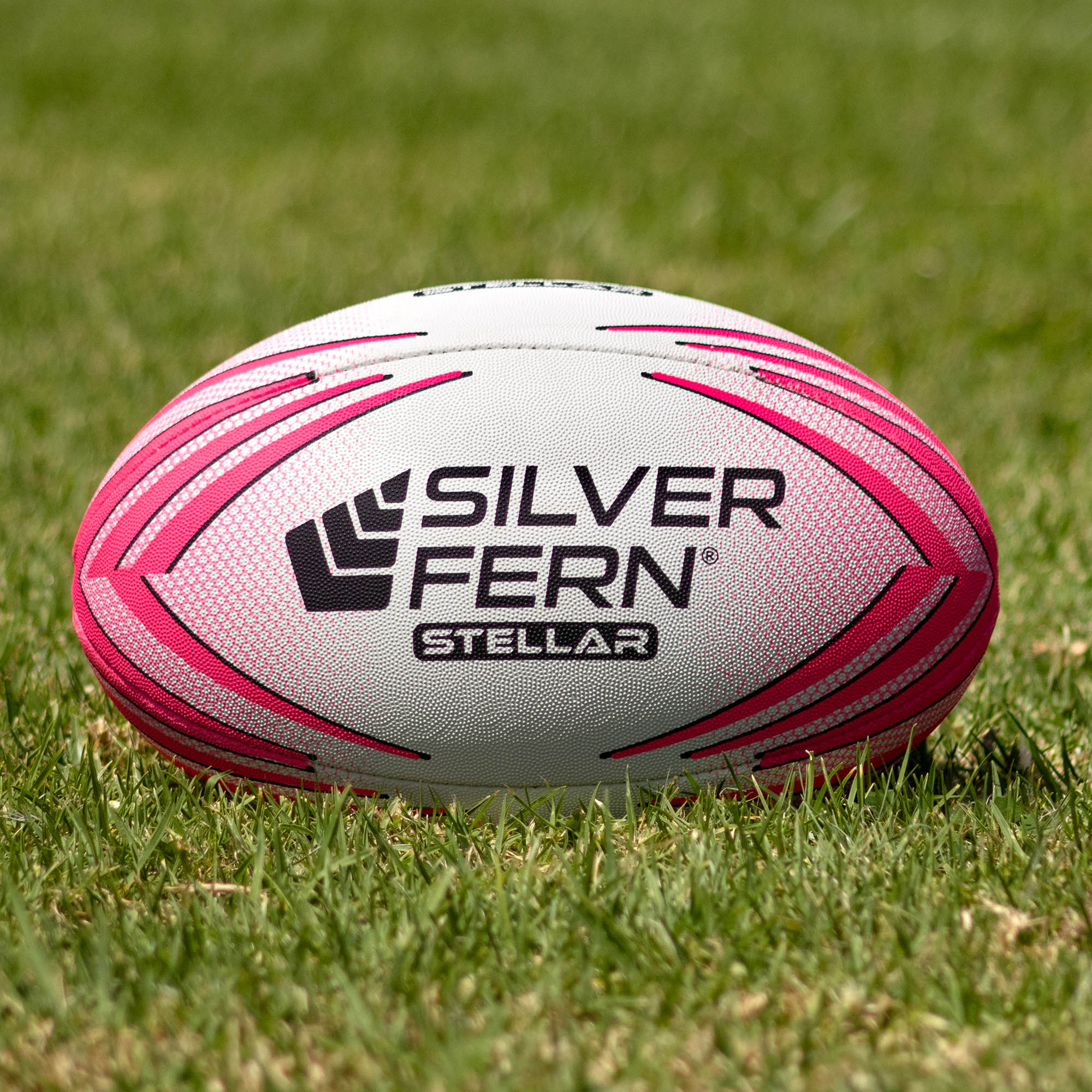 Silver Fern Pink Stellar Premium Trainer Size 5, Lifestyle shot, sitting on a rugby field