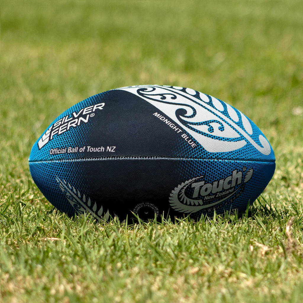 Silver Fern Touch Rugby Ball Midnight Blue Trainer, Lifestyle shot, sitting on a rugby field