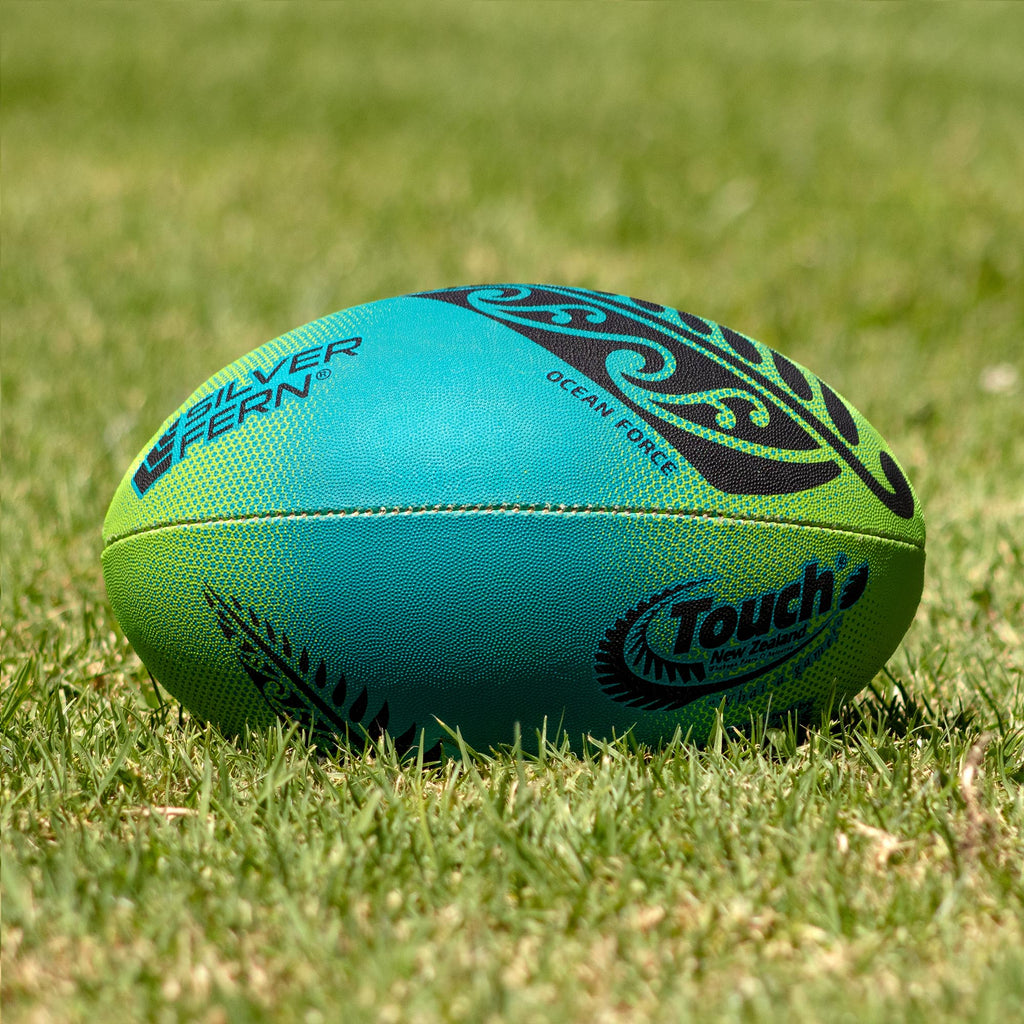 Silver Fern Touch Rugby Ball Ocean Force Trainer, Lifestyle shot, sitting on a rugby field
